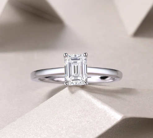 Anillo rectangular con moissanita certificada GRA apoyado sobre caja blanca, fondo blanco