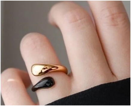 Modelo luciendo anillo negro esmaltado chapado en oro de 18K en el dedo anular