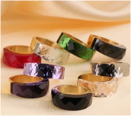 Anillos chapados en oro sobre pañuelo en fondo beige, apilados
