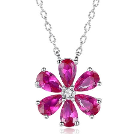 Foto del collar de flor multicolor en plata de ley sobre superficie blanca, mostrando los colores de los pétalos.
