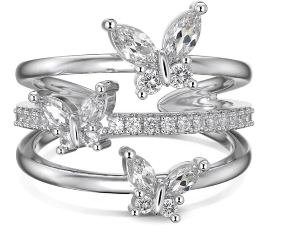 Anillo de mariposas completamente plateado sobre fondo blanco, mostrando los detalles simétricos y el acabado metálico.