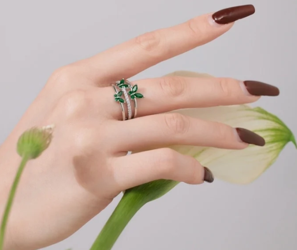 Mano con el anillo de mariposas en verde y plateado, demostrando cómo luce en el día a día.
