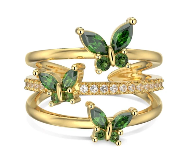 Anillo verde con detalles dorados sobre superficie lisa, mostrando el diseño atrevido y vibrante