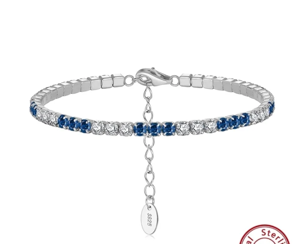 Pulsera tenis chapada en platino con circonitas azules y blancas sobre fondo blanco