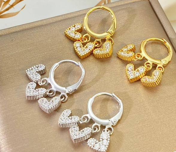 Vista lateral de los pendientes con zirconitas sobre charms de corazón