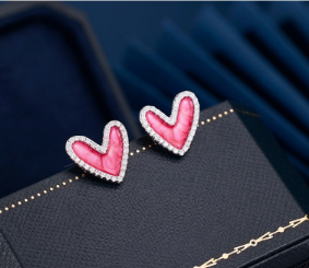 Pendientes de corazón rosa con pavé de circonitas sobre fondo blanco