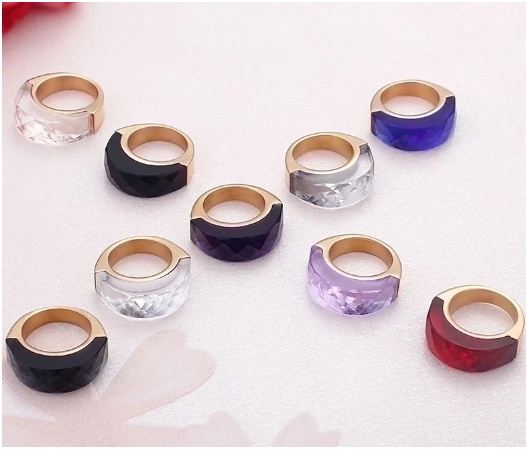 Anillos chapados en oro de 18K formando una X sobre fondo blanco