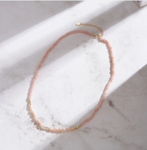 Collar Trendor con Perlas Rosas y Detalles en Oro 18K sobre fondo de mármol