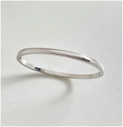 Brazalete de acero inoxidable plateado de 4mm sobre fondo blanco con sombra minimalista.