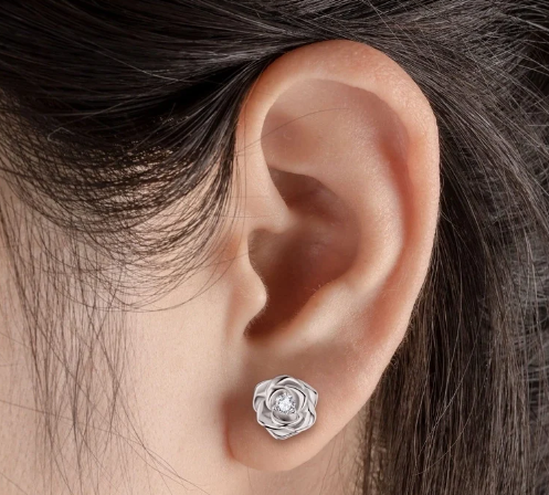 Modelo luciendo pendientes florales de moissanita chapados en oro rosa