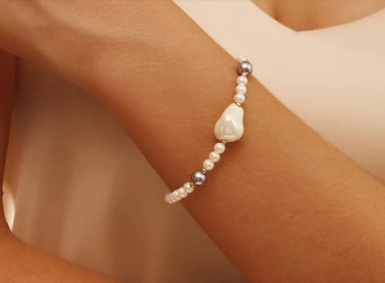 Modelo luciendo pulsera Princesa con perlas y detalles purpuras