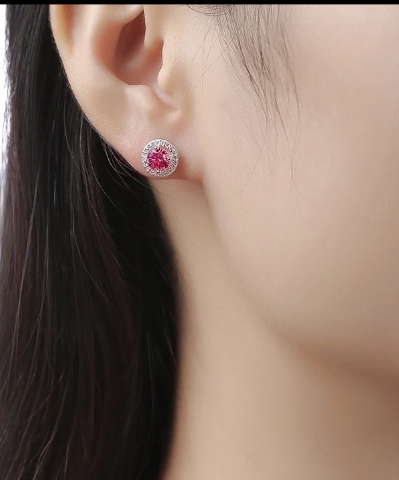 Mujer con pendientes de moissanita granate y plata, vistos puestos en oreja