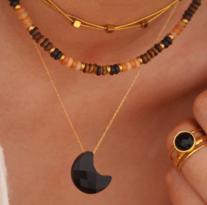 Modelo luciendo el collar de ágata negra en forma de luna sobre fondo neutro, elegante y minimalista