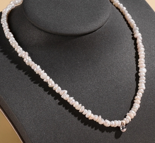 Modelo luciendo collar de perlas naturales con detalle central de plata