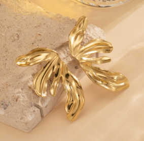 Vista de los pendientes Flor de Fuego en diferentes ángulos, mostrando su detalle y forma floral en fondo beige
