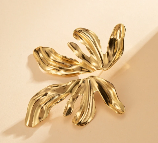 Pendientes Flor de Fuego en conjunto sobre fondo beige, destacando su diseño floral en oro 18k