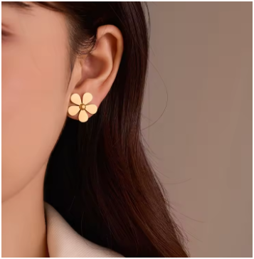 Pendientes grandes en forma de margarita, acero inoxidable dorado chapado en oro de 18K, modelo mostrada parcialmente, joyería elegante y moderna para destacar el look.