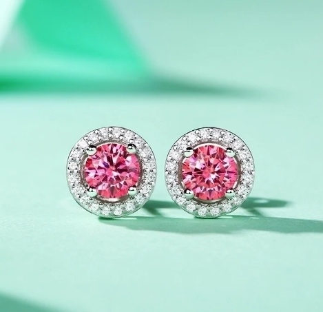 Detalle de pendientes con moissanita granate en fondo verde suave