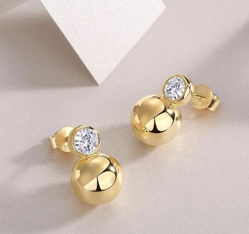Pendientes de plata con moissanita proyectando sombra, uno recto y otro girado