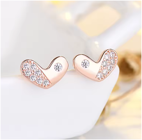 Los pendientes en oro rosa descansan sobre la cerámica blanca, destacando el brillo del metal.