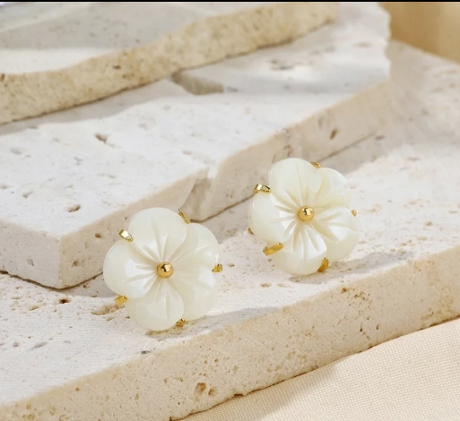 Pendientes florales de concha natural sobre elegante balda de mármol, chapados en oro 18k.