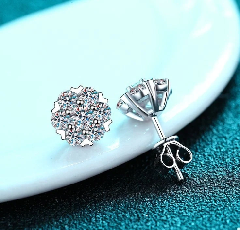 Pendientes de plata con moissanita apoyados en joyero azul, cierre a presión visible