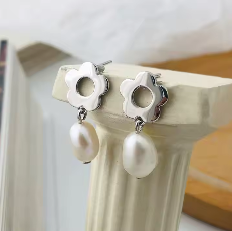 Pendientes flor en plata S925, exhibidos sobre columna romana