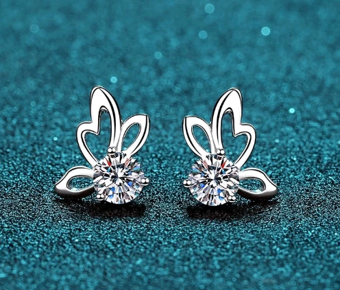 Pendientes mariposa con moissanita vistos de frente sobre fondo azul