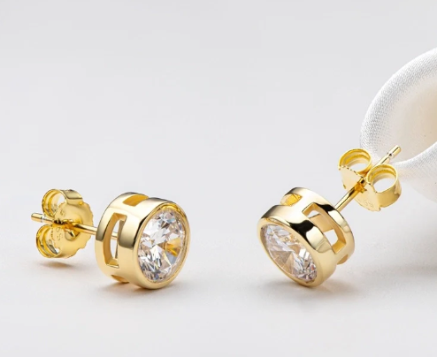 Pendientes de moissanita en forma de corazón en oro amarillo, fotografía en vista inclinada sobre fondo blanco.