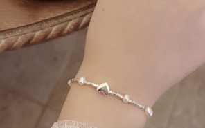 Modelo Luciendo Pulsera con Corazón de Plata y Perla de Agua Dulce