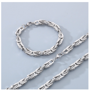 Modelo masculino con americana beige y manga remangada, mostrando pulsera de acero inoxidable 305 chapada en oro 18K, estilo hip-hop, mano en el bolsillo.