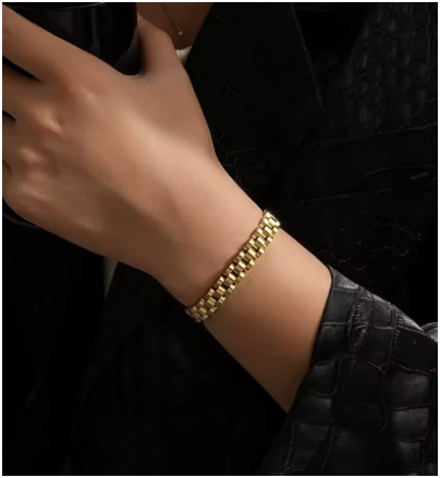 Pulsera de hombre en acero de titanio chapada en oro, estilo hip-hop, mostrada en la muñeca de un modelo con jersey negro y manga remangada. Colección Hellochic@s-MEN.