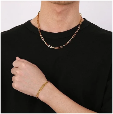 Modelo masculino con camiseta negra mostrando pulsera chapada en plata en el brazo doblado.