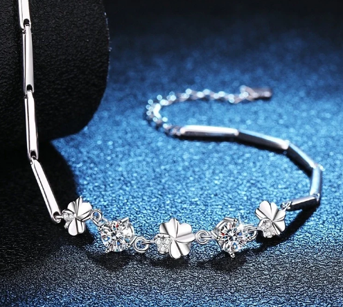 Pulsera tubular de plata esterlina con tréboles y moissanita sobre fondo azul