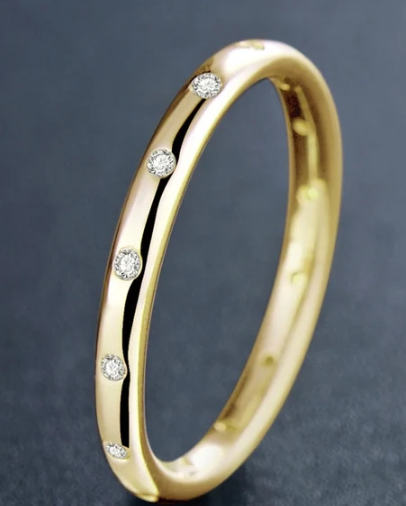 Mano femenina luciendo el anillo clásico bicolor en una escena cotidiana con luz natural.