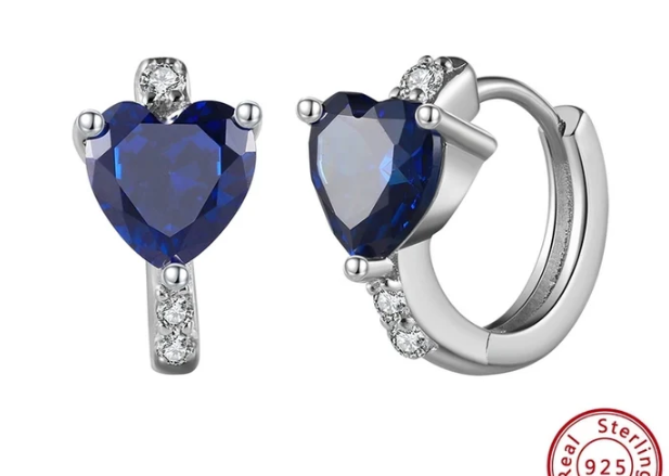 Pendientes con corazón azul zafiro y zirconitas blancas sobre fondo neutro