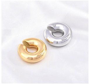 Pendientes ear cuff dorado y plateado en acero inoxidable, vistos desde arriba, diseño minimalista y moderno sin perforación