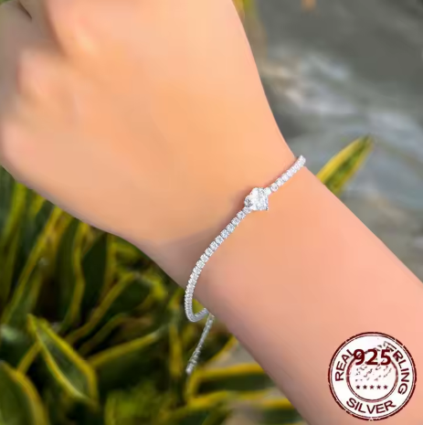 Modelo luciendo la pulsera tenis de corazón blanco. Estilo elegante y romántico.