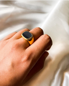  Modelo luciendo anillo con nácar y oro 18k, contraste elegante sobre fondo negro
