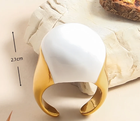 Anillo geométrico blanco esmaltado con detalles dorados, muestra de la talla y diseño minimalista