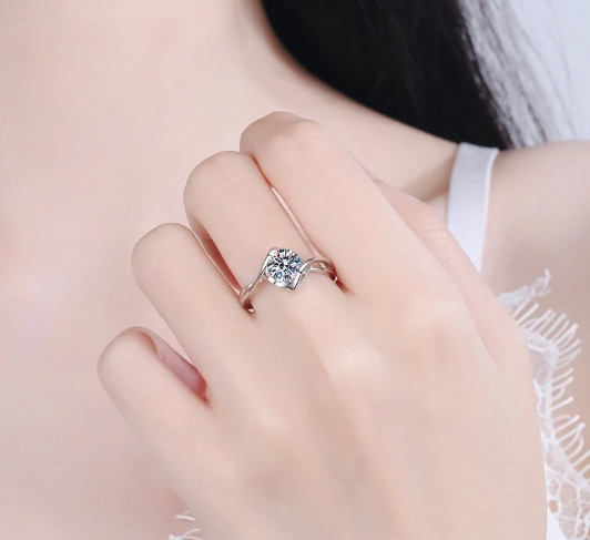 Modelo mostrando anillo solitario de moissanita en forma de corazón en el dedo anular mientras toca su hombro