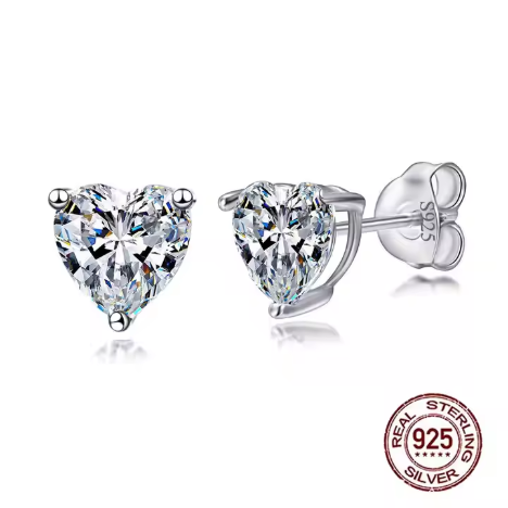 Pendientes de plata 925 con circonita en forma de corazón brillando bajo luz suave, sobre fondo blanco, mostrando detalle del tallado