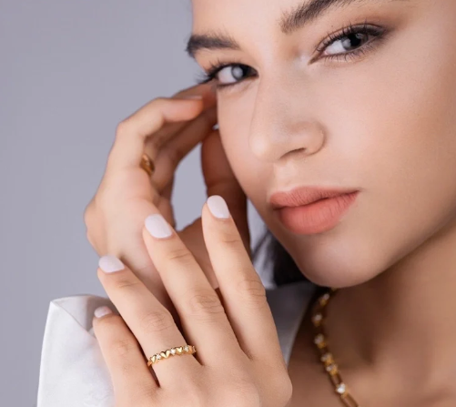 Modelo tocándose la cara con anillo de moissanita corazón en dedo anular