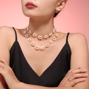 Modelo llevando dos collares de perlas con diseño de margaritas y cadena de plata