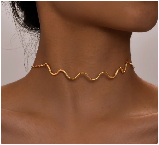Modelo luciendo la gargantilla Ondas chapada en oro, ajustada al cuello, con escote elegante