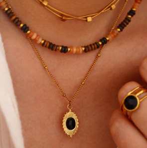 Modelo luciendo el collar retro francés con ágata negra ovalada y cadena de titanio chapado en oro 18k