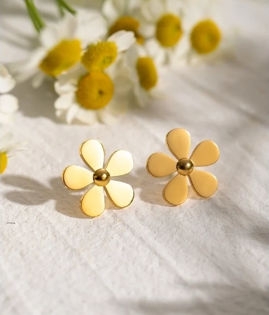 Pendientes flor minimalistas, chapados en oro 18K, acompañados de margaritas sobre fondo blanco