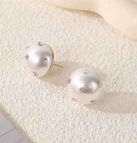 Pendientes de botón de perla con diamantes artificiales en plata de ley 925 sobre fondo blanco.