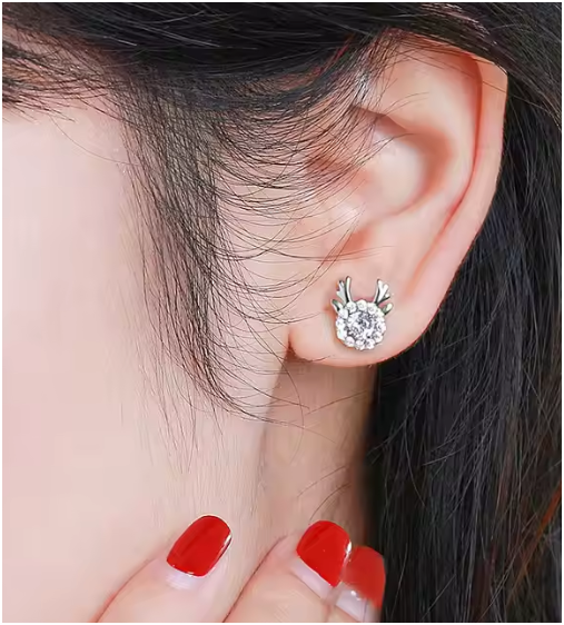 Pendientes de plata puestos en la oreja derecha de la modelo, mostrando su elegancia discreta.