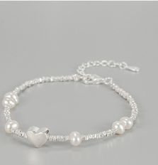 Pulsera de Plata con Corazón de Plata y Perla de Agua Dulce en Fondo Gris